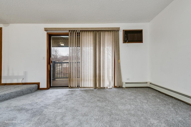 spare room with a wall mounted air conditioner, a textured ceiling, and carpet