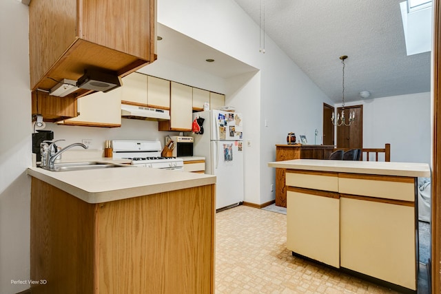 kitchen with kitchen peninsula, a textured ceiling, white appliances, sink, and a notable chandelier