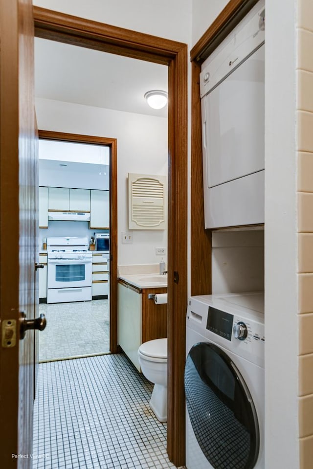 bathroom with stacked washer and dryer, vanity, and toilet