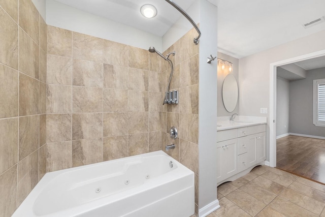 bathroom with tile patterned floors, vanity, and tiled shower / bath combo