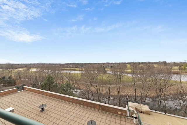 view of patio with a balcony and a water view