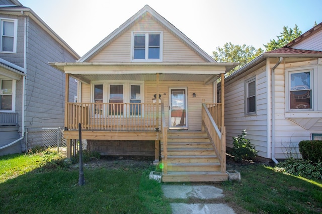 bungalow-style home with covered porch and a front yard