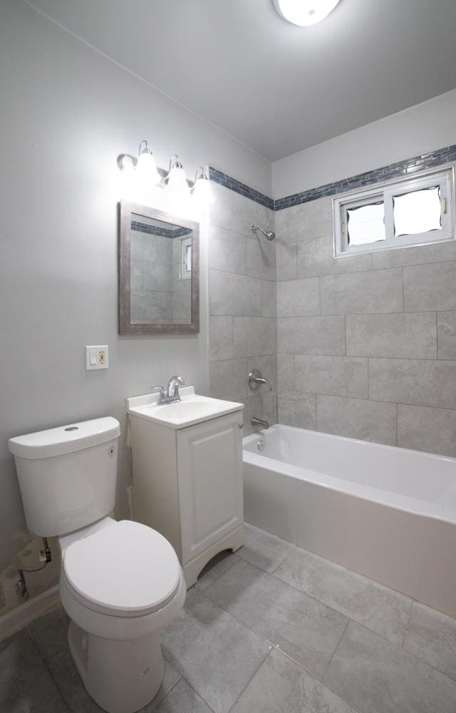 full bathroom with tile patterned floors, tiled shower / bath combo, toilet, and vanity