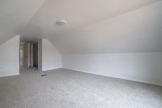 additional living space featuring carpet and lofted ceiling