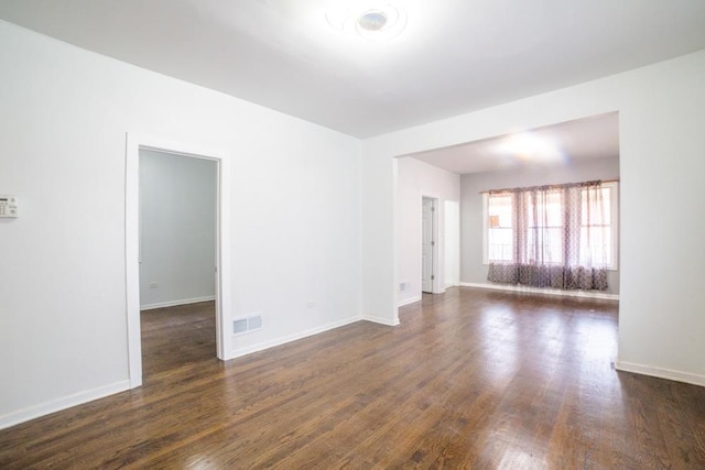 spare room with dark wood-type flooring