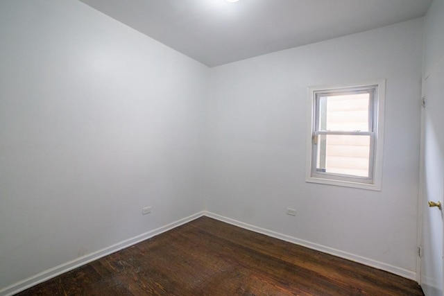 empty room with dark hardwood / wood-style flooring