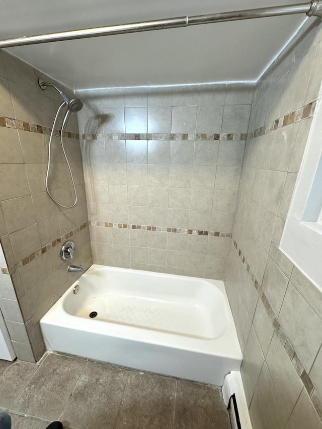 bathroom with a baseboard radiator and tiled shower / bath