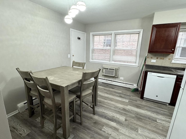 dining room featuring a wall mounted AC, hardwood / wood-style floors, and baseboard heating