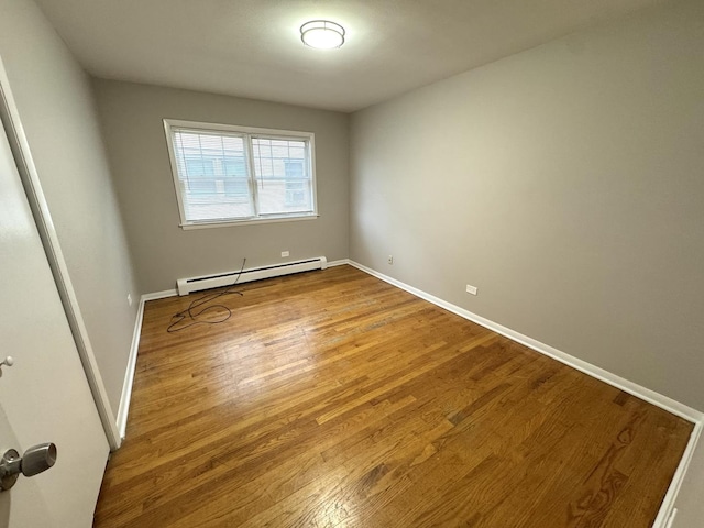 spare room featuring hardwood / wood-style floors and baseboard heating