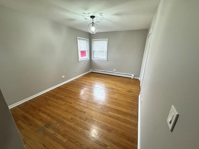 spare room with a baseboard radiator and hardwood / wood-style flooring