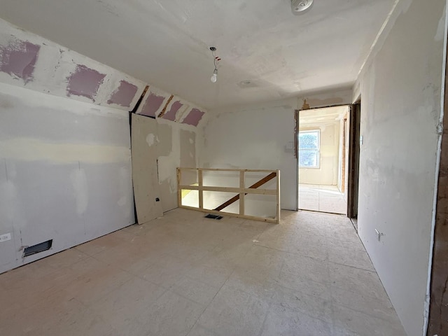 unfurnished room with vaulted ceiling