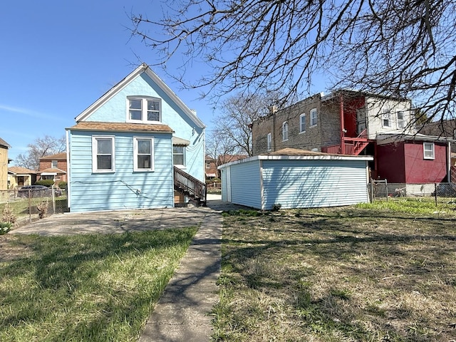 rear view of property with a yard and fence