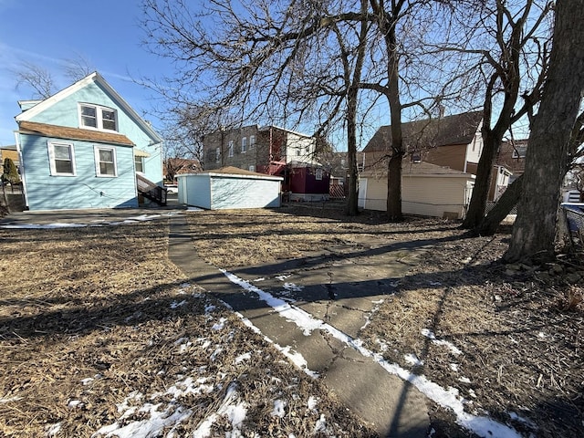 snowy yard with an outbuilding and a garage