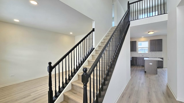 staircase featuring hardwood / wood-style floors and sink