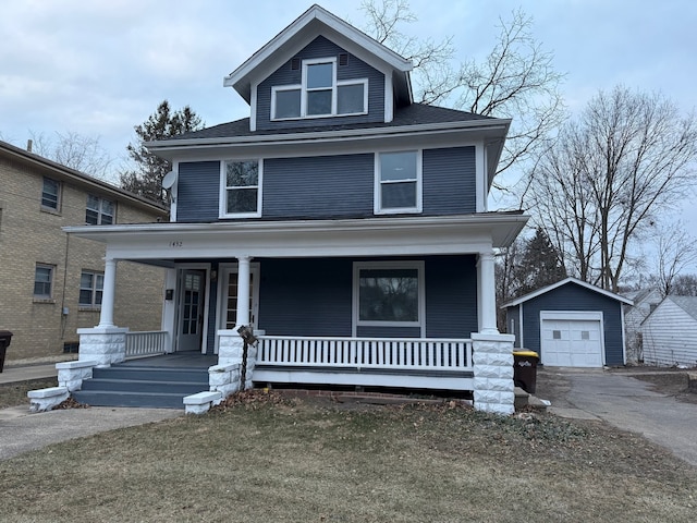 view of front of home featuring a porch, a garage, and an outdoor structure