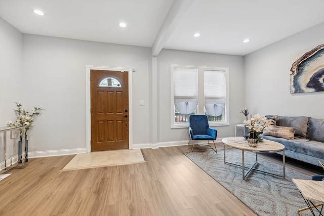 entryway with light hardwood / wood-style floors and beam ceiling