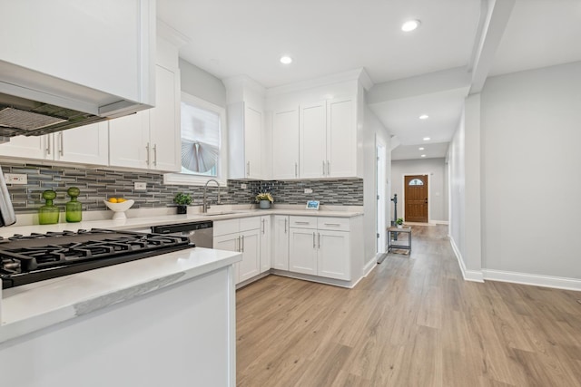 kitchen featuring backsplash, white cabinets, ventilation hood, sink, and light hardwood / wood-style flooring