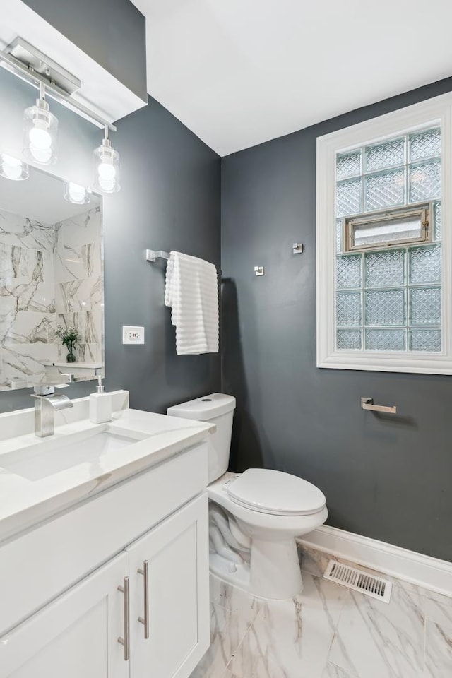 bathroom with decorative backsplash, vanity, and toilet