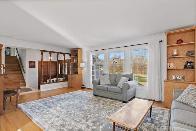 living room featuring wood-type flooring and ornamental molding