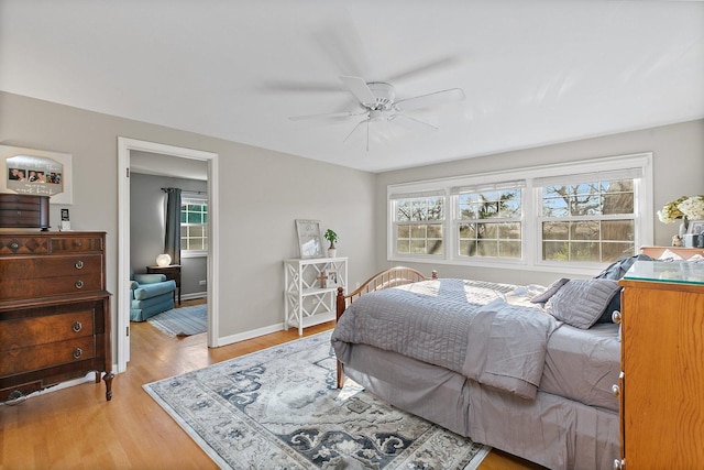 bedroom featuring light hardwood / wood-style floors, multiple windows, and ceiling fan