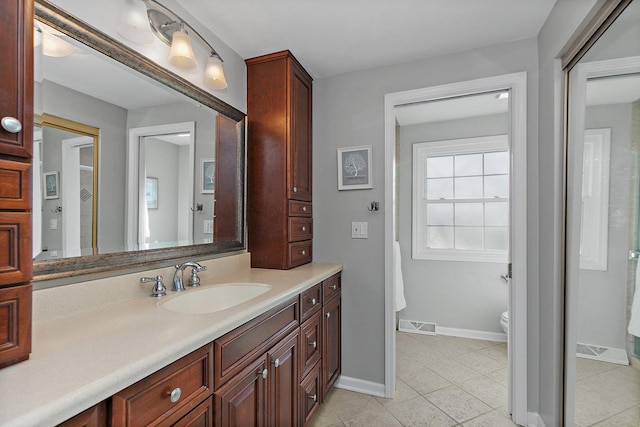 bathroom featuring toilet, vanity, and tile patterned floors