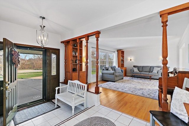 foyer entrance with light hardwood / wood-style floors, a wealth of natural light, and a chandelier