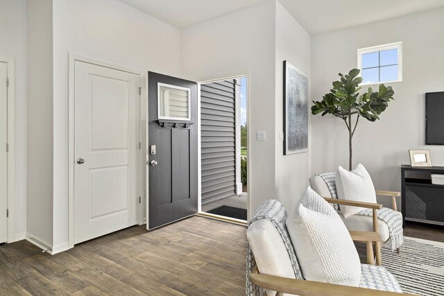 kitchen with white cabinetry, sink, stainless steel appliances, hardwood / wood-style floors, and an island with sink