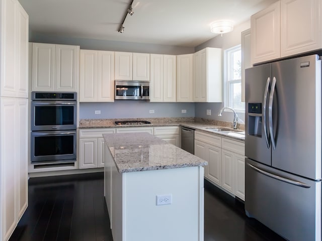 20137 Preston Ln, Lynwood, IL 60411 - kitchen with stainless steel appliances, a kitchen island, dark wood finished floors, and light stone counters