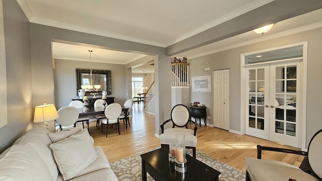 living room featuring french doors, light hardwood / wood-style flooring, and crown molding