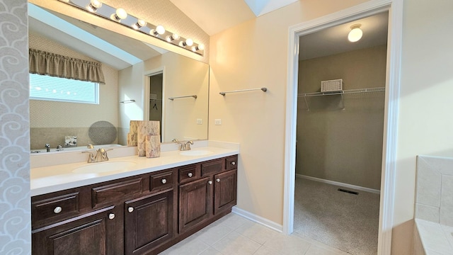 bathroom featuring tile patterned flooring, vanity, and lofted ceiling