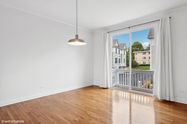 spare room with ornamental molding and hardwood / wood-style floors