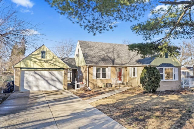 cape cod home featuring a shingled roof, concrete driveway, an attached garage, fence, and brick siding