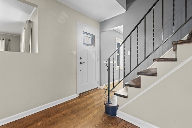 entryway with crown molding, stairs, baseboards, and wood finished floors