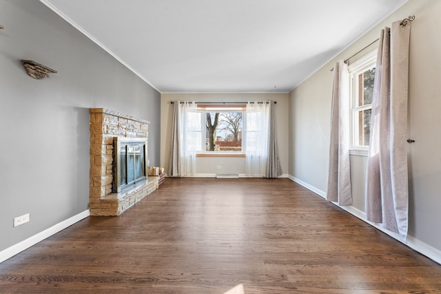 unfurnished living room with dark wood-style floors, plenty of natural light, a fireplace, and ornamental molding