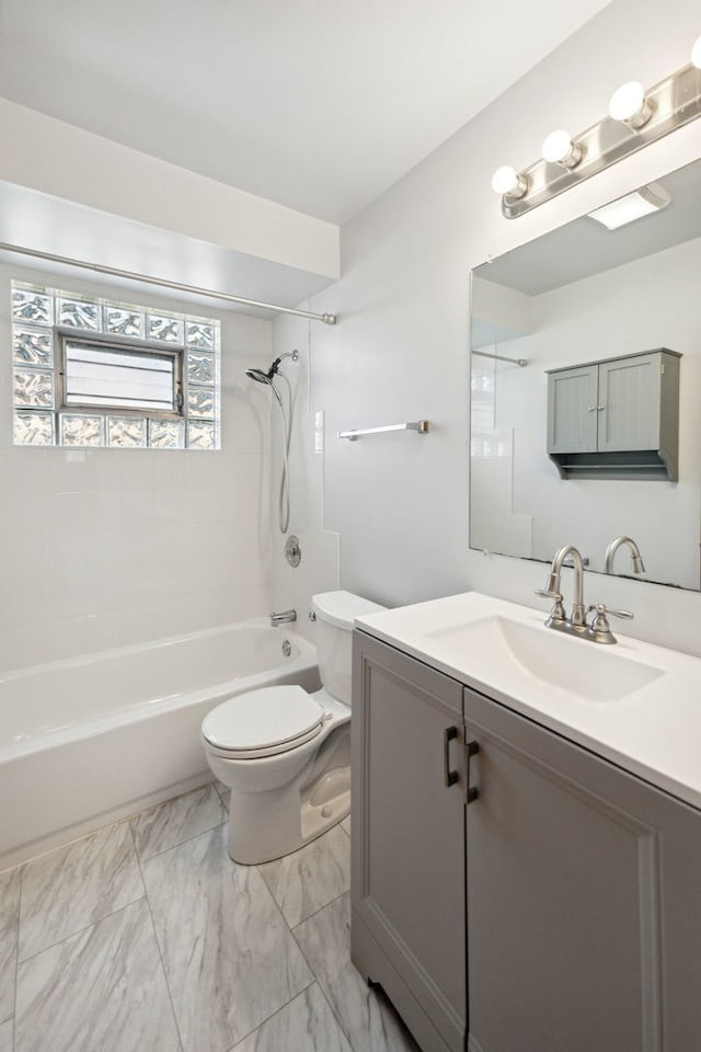 full bathroom featuring tiled shower / bath combo, toilet, and vanity