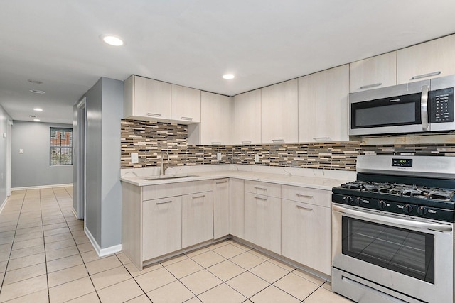 kitchen featuring backsplash, light stone counters, stainless steel appliances, sink, and light tile patterned floors