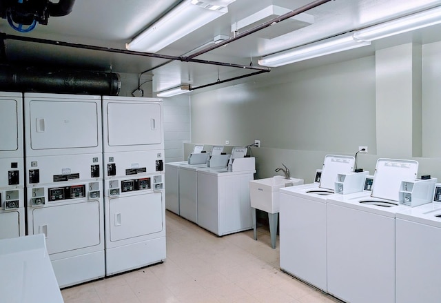 laundry area featuring stacked washer and dryer, sink, and washing machine and clothes dryer