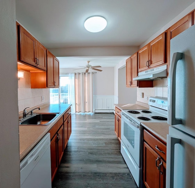 kitchen featuring baseboard heating, decorative backsplash, sink, and white appliances