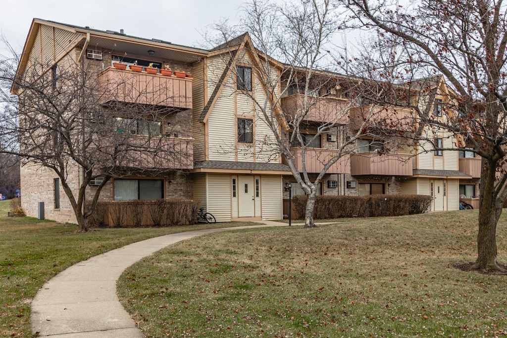 view of front of house featuring a front yard and a balcony