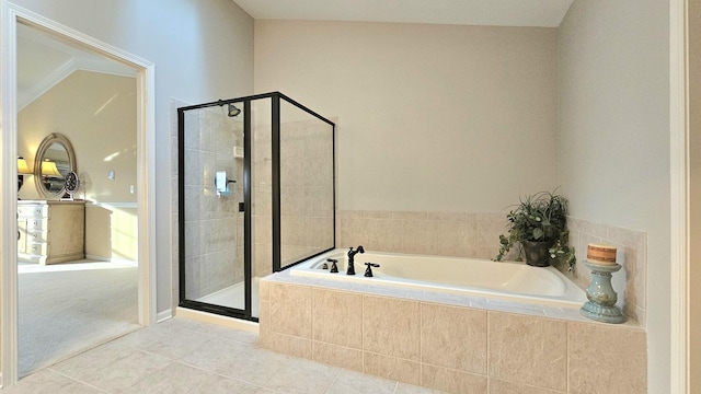 bathroom with tile patterned flooring, separate shower and tub, and vaulted ceiling