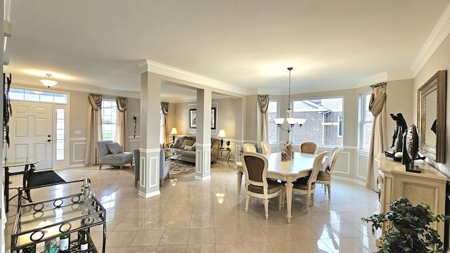 dining room featuring decorative columns, ornamental molding, and a notable chandelier