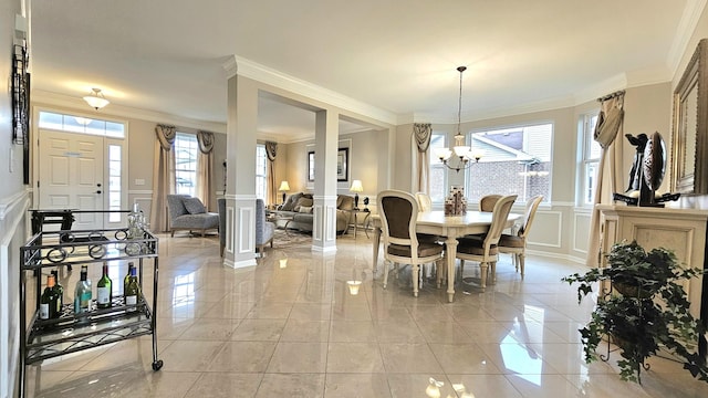 dining room featuring ornate columns, crown molding, and a chandelier