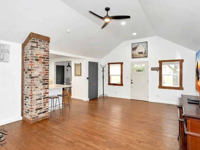 unfurnished living room with dark hardwood / wood-style floors, ceiling fan, and vaulted ceiling