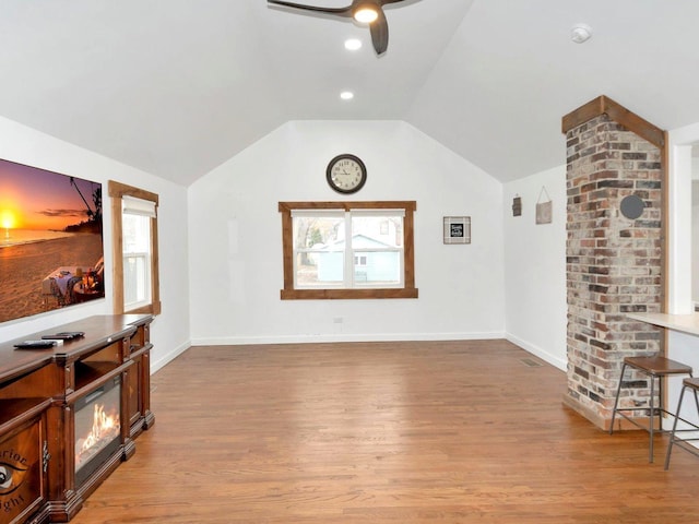 living room featuring a wealth of natural light, ceiling fan, light hardwood / wood-style floors, and lofted ceiling