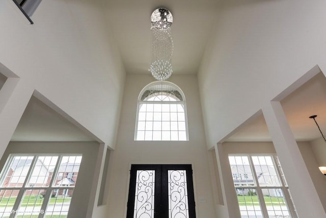 entryway featuring french doors, a high ceiling, and an inviting chandelier