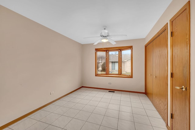 unfurnished bedroom with ceiling fan, a closet, and light tile patterned floors