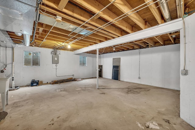 basement with electric panel and a healthy amount of sunlight