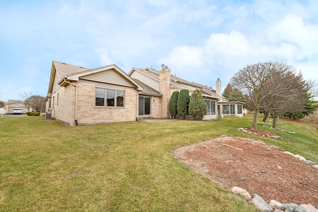 rear view of property featuring a lawn and a sunroom