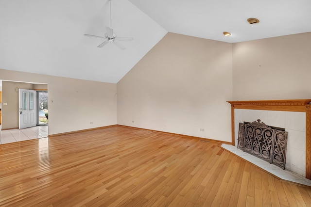 unfurnished living room featuring a fireplace, ceiling fan, light hardwood / wood-style flooring, and lofted ceiling