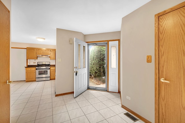 kitchen featuring stainless steel gas range oven and light tile patterned flooring